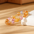Yellow tower quartz and strawberry quartz bracelet on warm sunlit paper