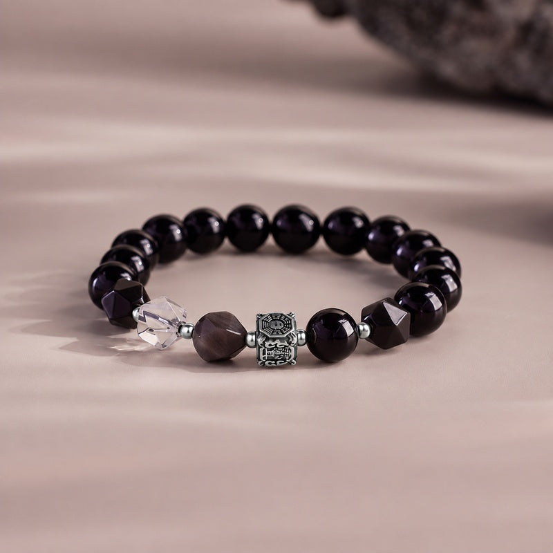Yin yang Bagua obsidian bracelet on a softly lit taupe background