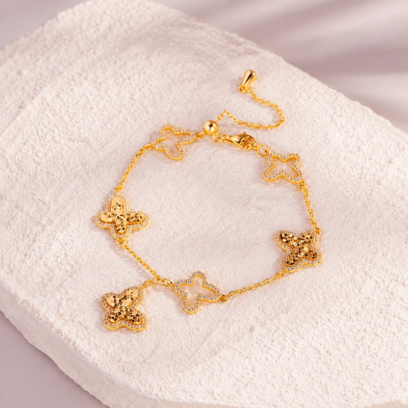 Gold-tone butterfly bracelet on pale textured stone