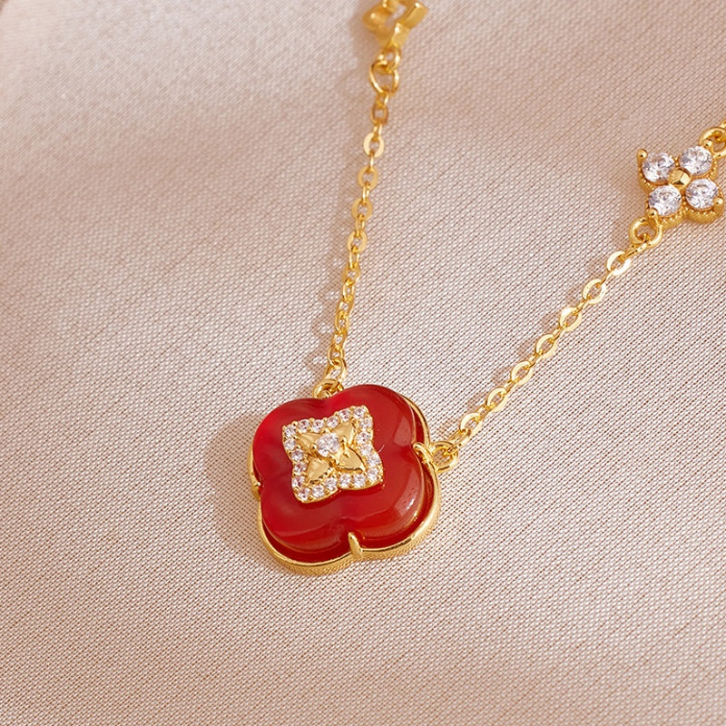 Red agate pendant and gold-tone chain on fabric