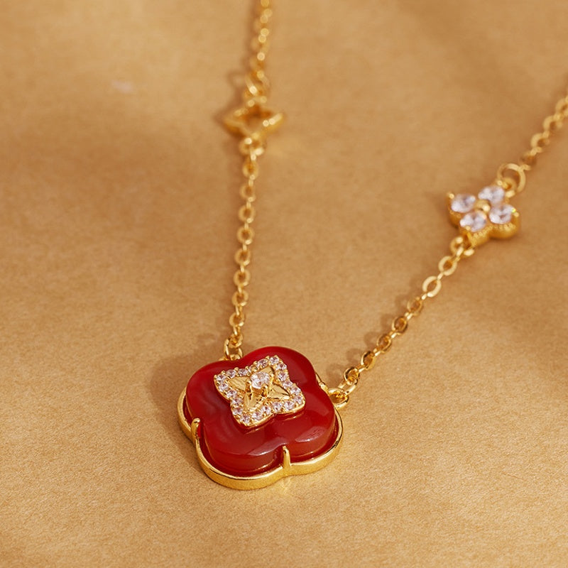 Clover necklace detail against golden paper