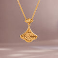 Ginkgo leaf silver necklace suspended against a softly lit taupe background