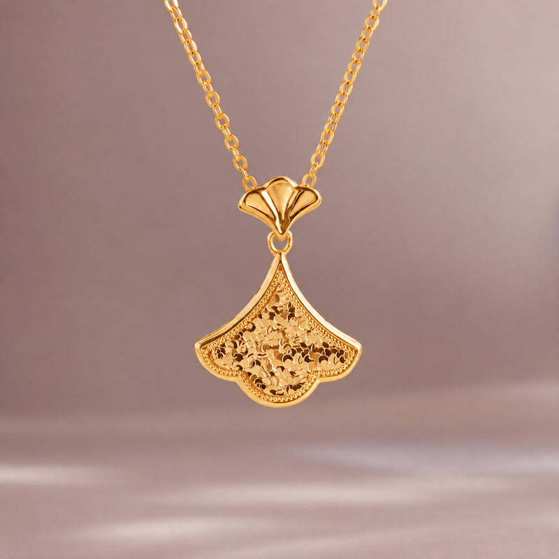 Ginkgo leaf silver necklace suspended against a softly lit taupe background