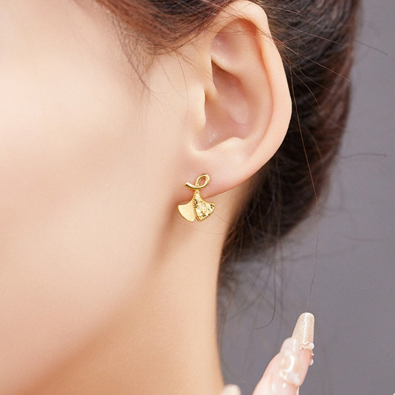 Ginkgo leaf stud earring worn by the supplier model with hand nearby