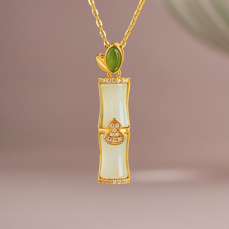 Nephrite jade bamboo gourd necklace on a soft mauve background