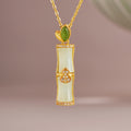 Nephrite jade bamboo gourd necklace on a soft mauve background