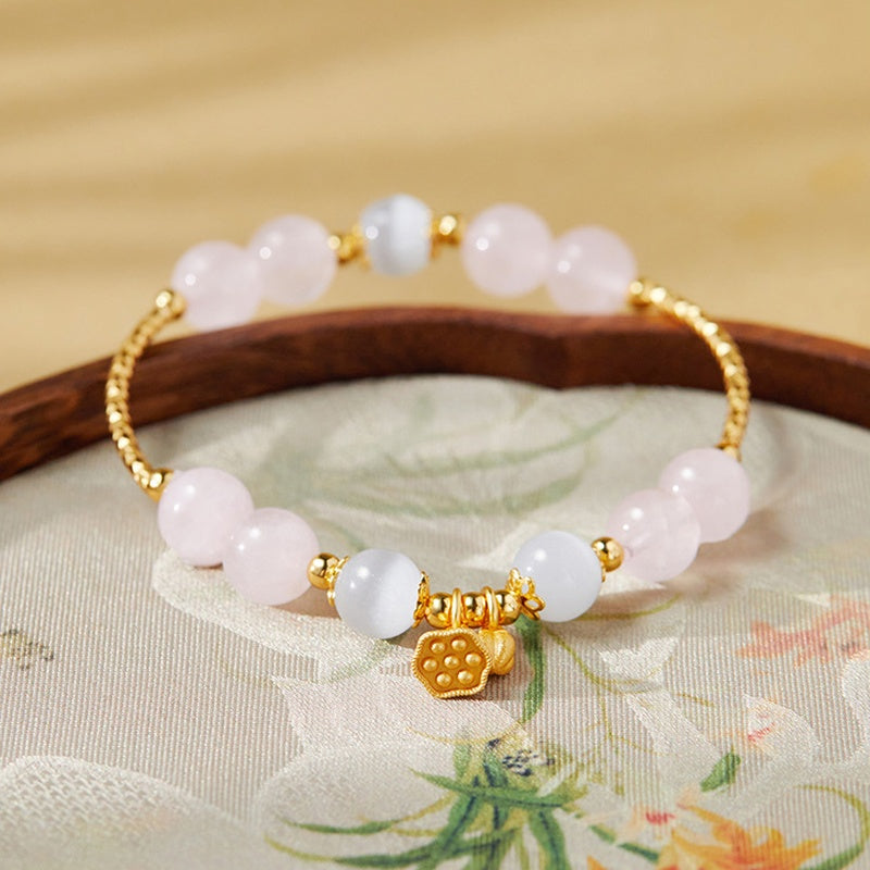 Rose quartz and white cat-eye glass bracelet with lotus seedpod and bud on embroidered fabric