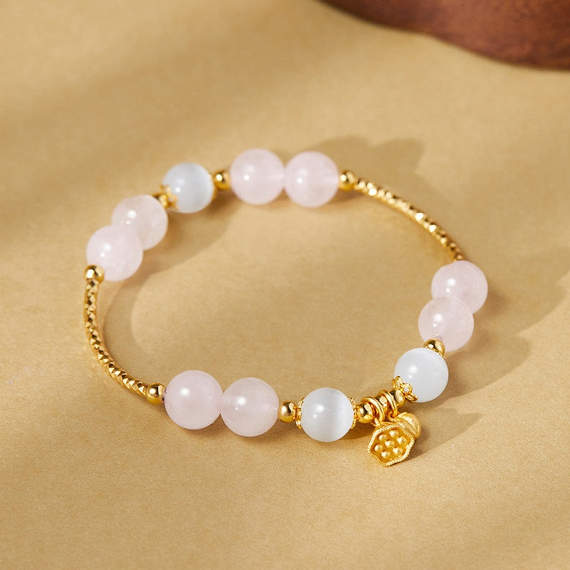 Rose quartz lotus bracelet on warm sand-colored background