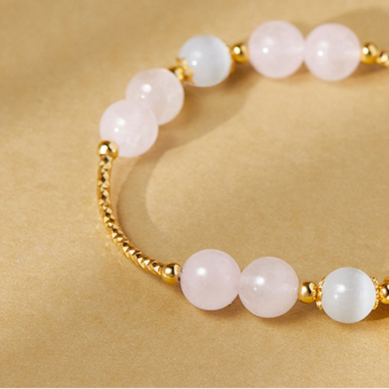 Pink rose quartz beads and textured gold-tone arcs