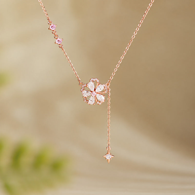 Peach blossom silver tassel necklace against a warm blurred background
