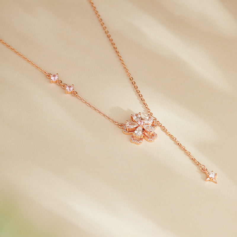Peach blossom silver necklace resting on golden satin