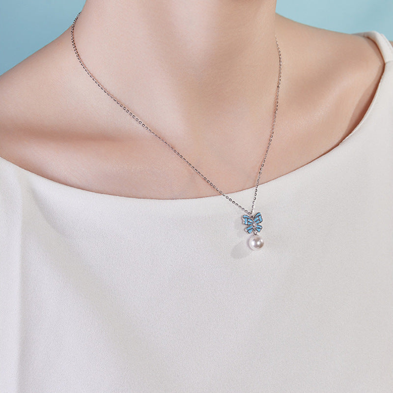 Supplier model wearing the blue enamel bow and imitation pearl necklace