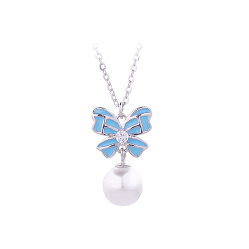 Blue bow and imitation pearl necklace on white