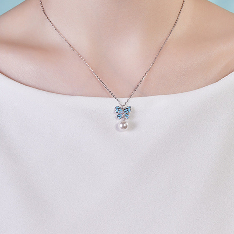 Front supplier model view of the blue bow and imitation pearl necklace