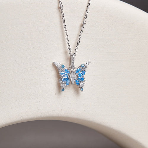 Blue cubic zirconia butterfly silver necklace on the original pale curved display