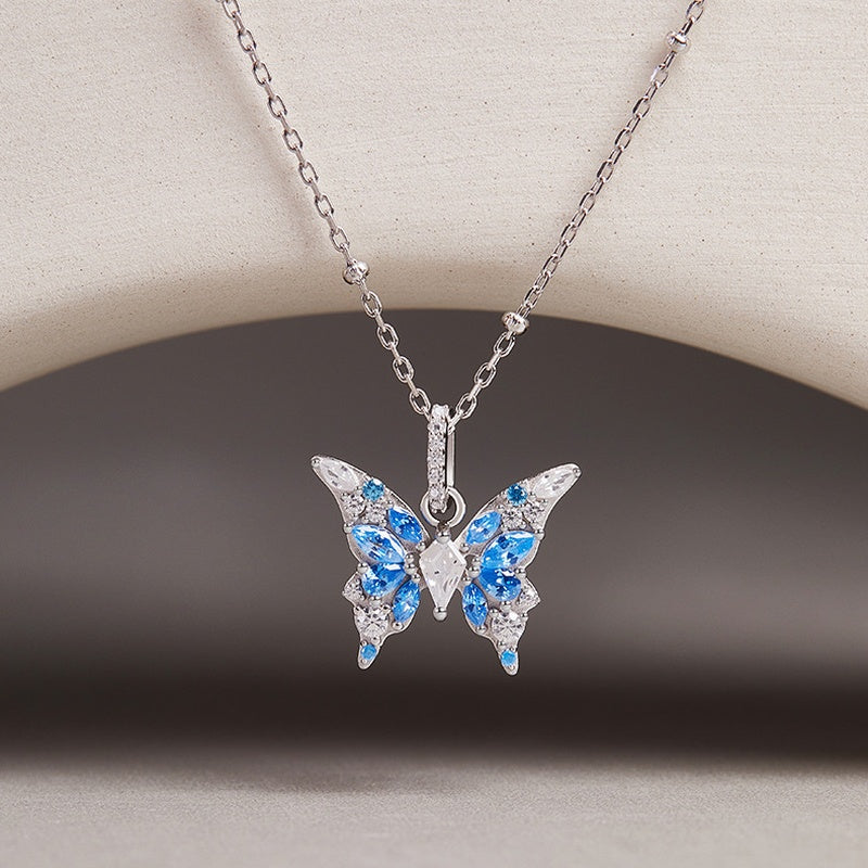 Original suspended butterfly necklace against a neutral background