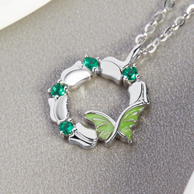 Close-up of green enamel wings and polished silver petals