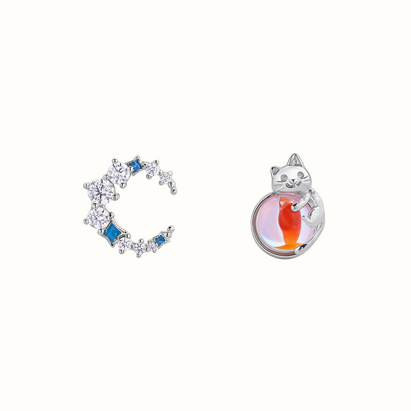Asymmetrical cat and crescent moon stud earrings on white