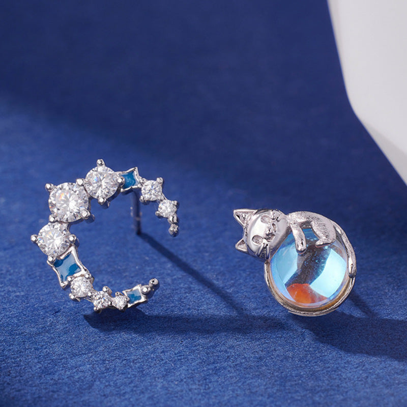 Cat and moon earrings on blue fabric
