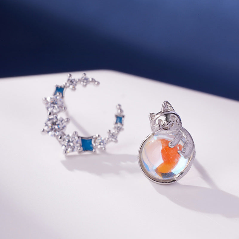 Close view of the iridescent cat and sparkling crescent earrings