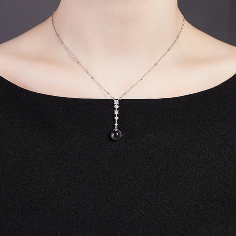 Supplier model wearing the clear quartz silver drop necklace with a black top