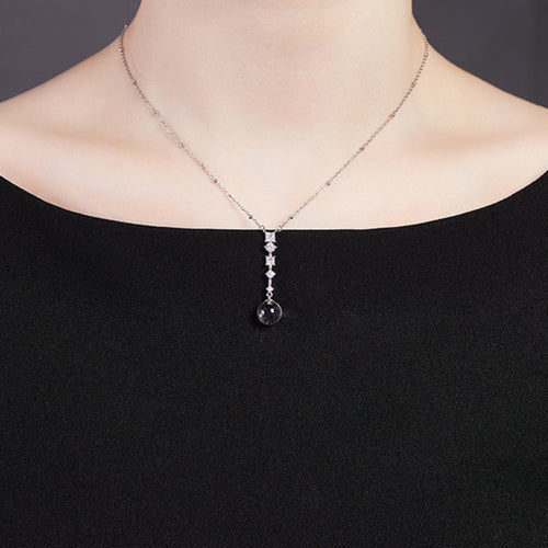 Supplier model wearing the clear quartz silver drop necklace with a black top