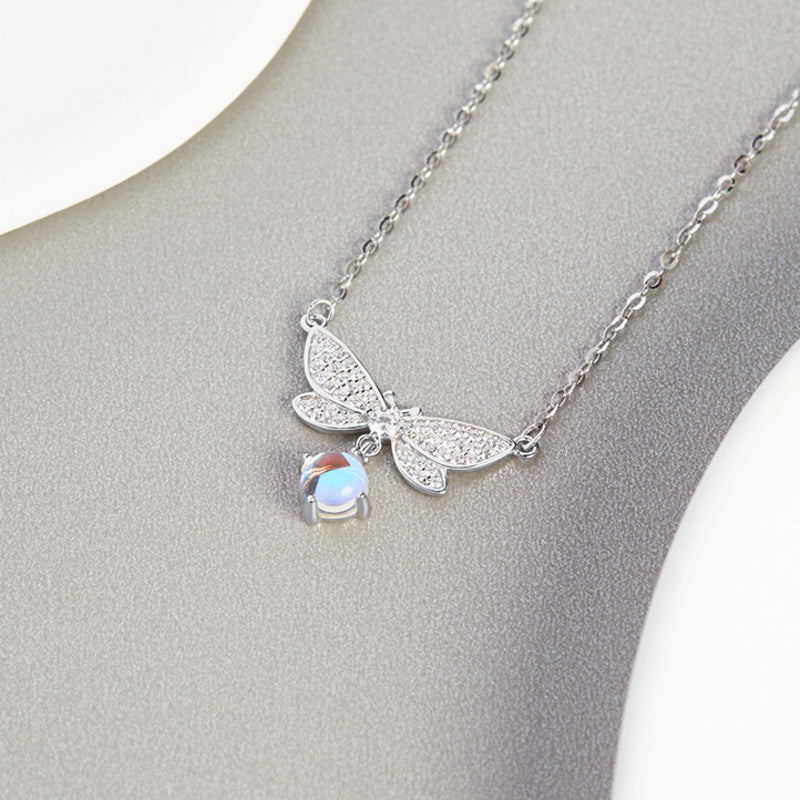 Dragonfly pendant on a textured gray surface