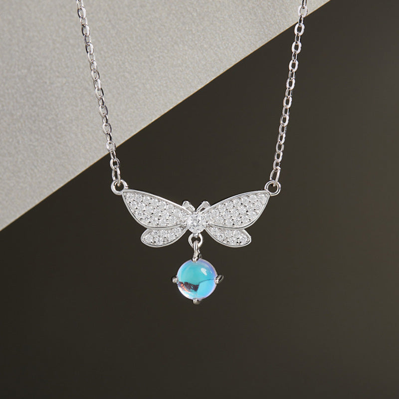 Dragonfly necklace with blue glass drop and diagonal background