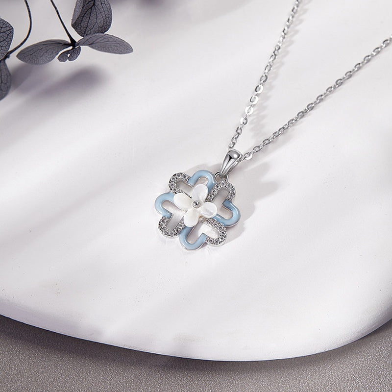 Blue clover necklace resting on a white display dish