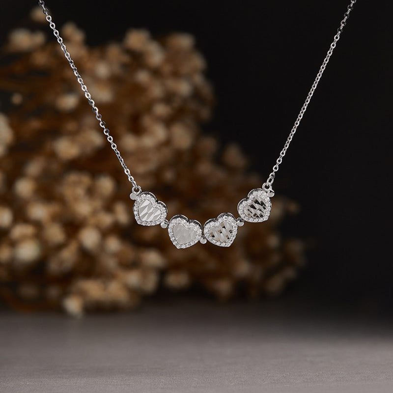 Necklace unfolded into four connected hearts against a dark floral background