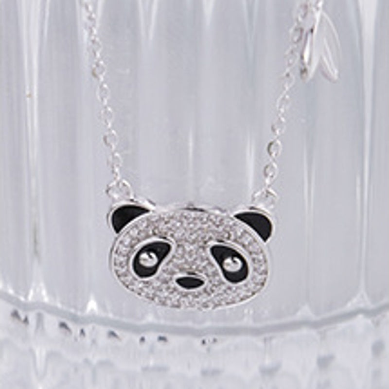 Front view of the panda pendant against textured glass