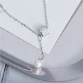 Imitation pearl tassel sterling silver necklace on a silver tray