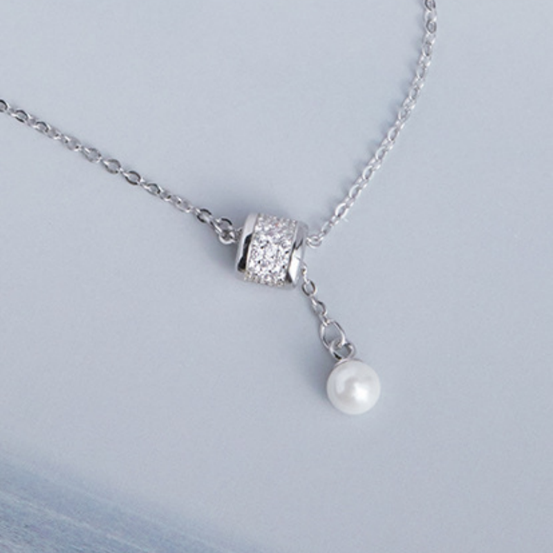 Close view of cubic zirconia pendant and imitation pearl tassel
