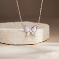 Photochromic cubic zirconia butterfly silver necklace on a cream stone display