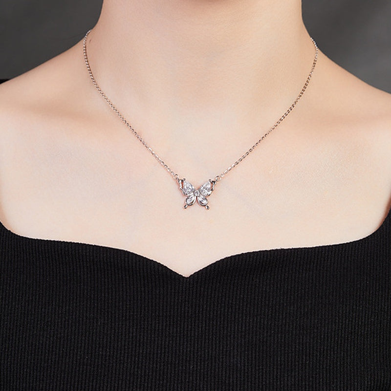 Original model wearing the butterfly necklace with a black neckline