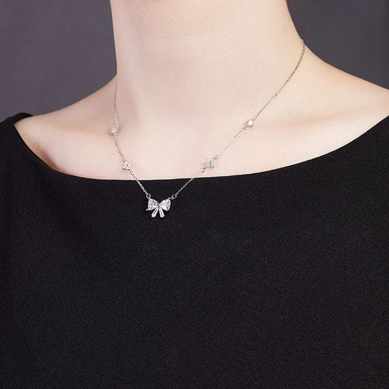 Angled model view of the silver bow necklace