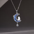 Cat and iridescent moon necklace with hanging bell against a gray background