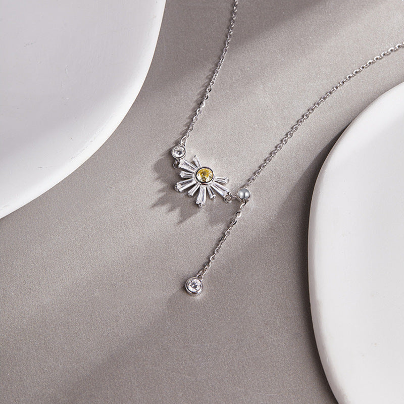 Daisy necklace detail on a gray surface