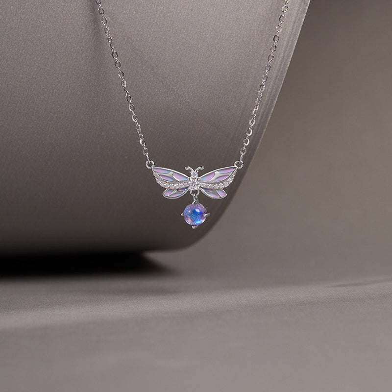 Purple enamel butterfly necklace against its original gray background