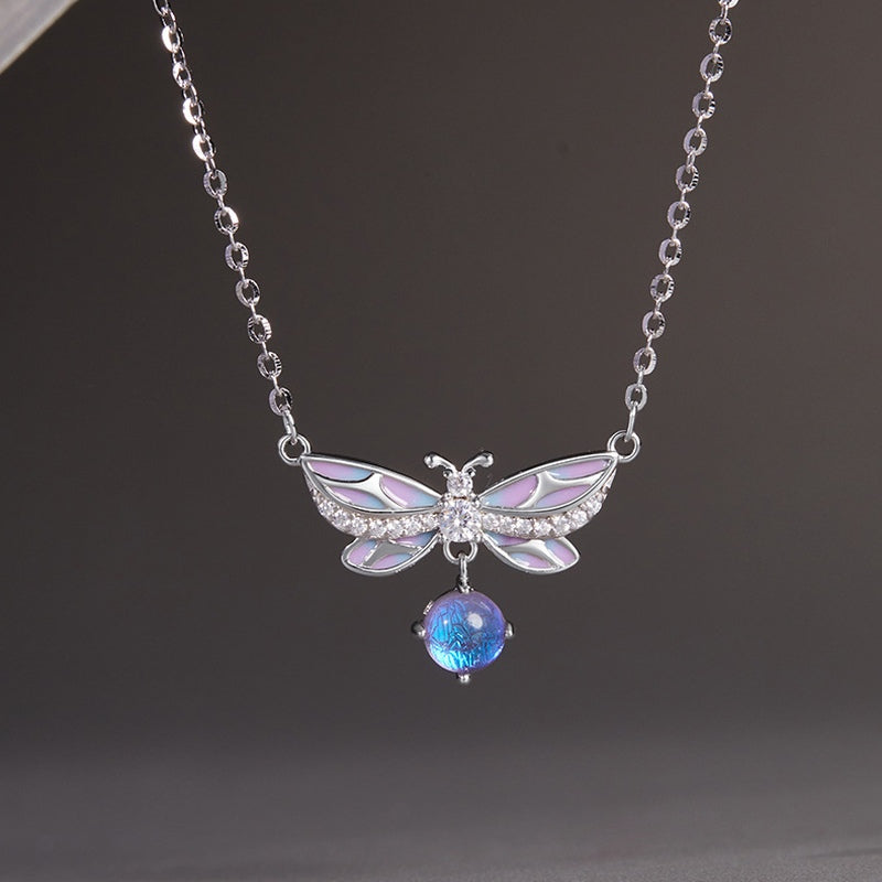 Front detail of purple enamel wings and blue-purple glass drop