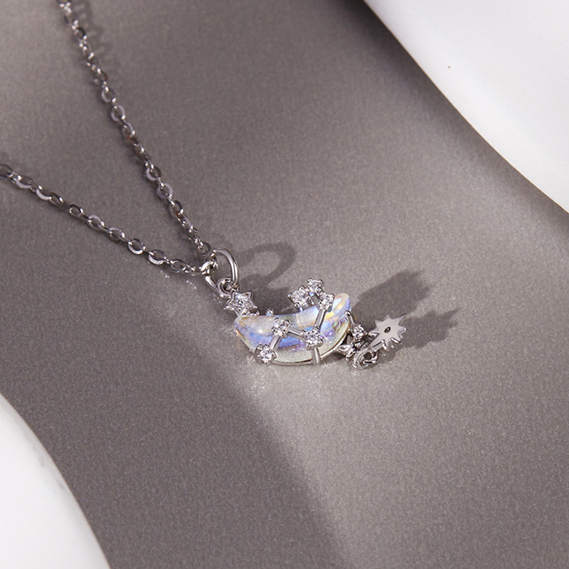 Star and moon necklace resting on a grey surface