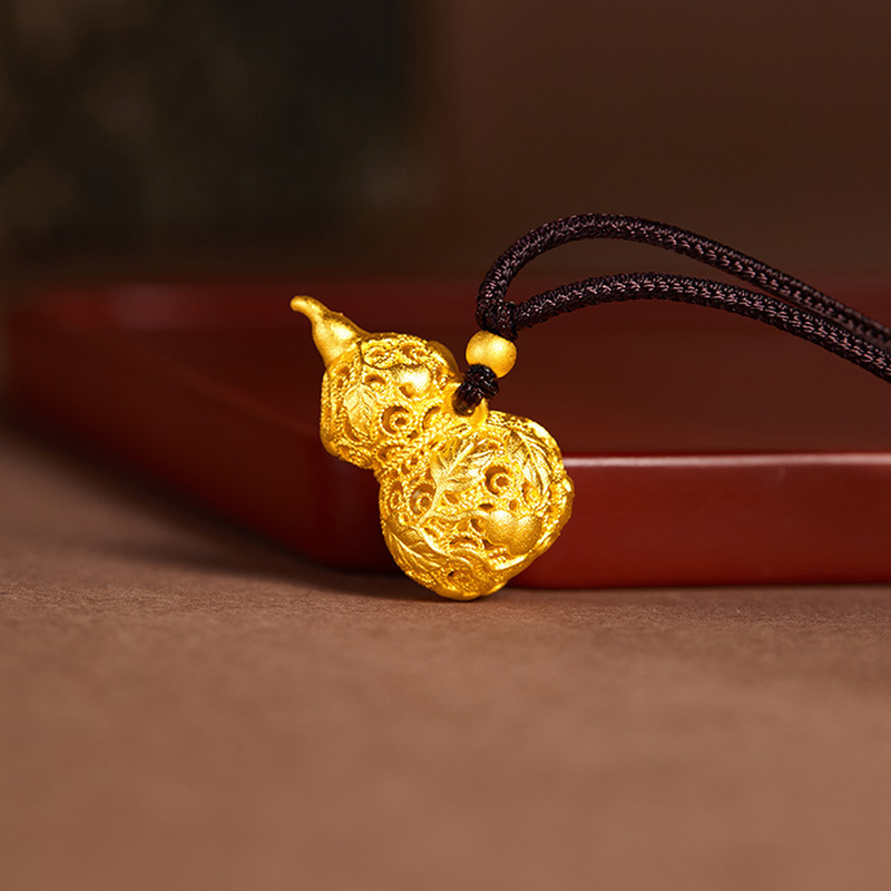Angled filigree gourd pendant beside a red tray