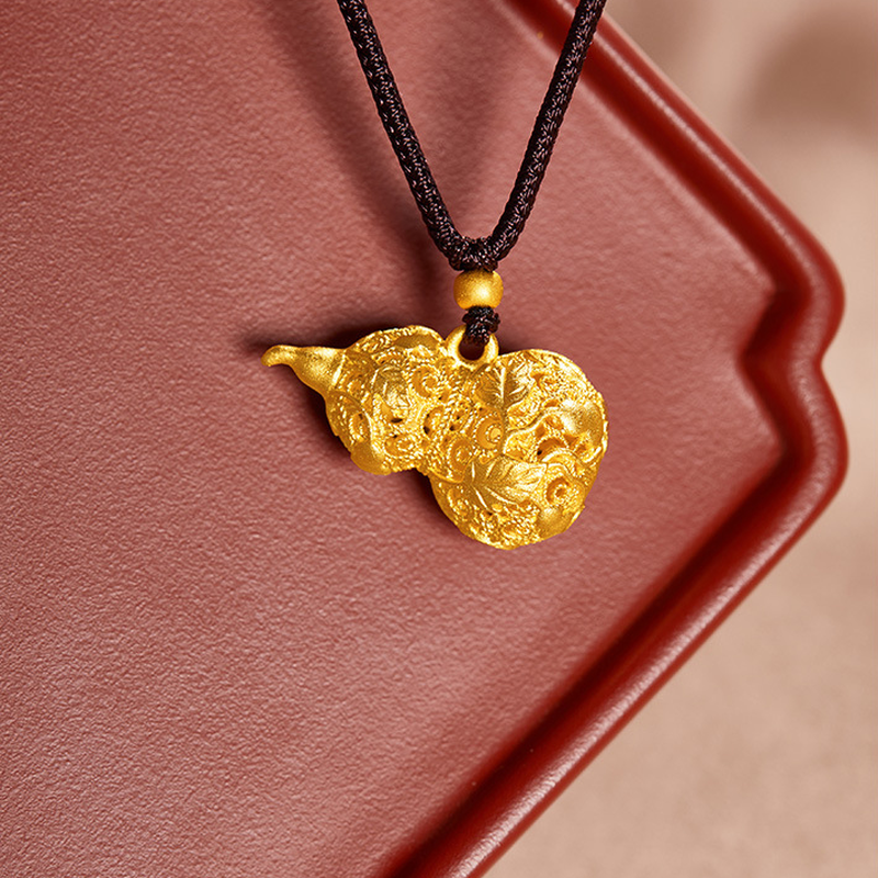 Filigree gourd pendant resting on a red tray