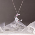 Moon and blossom necklace suspended against gray and white lace