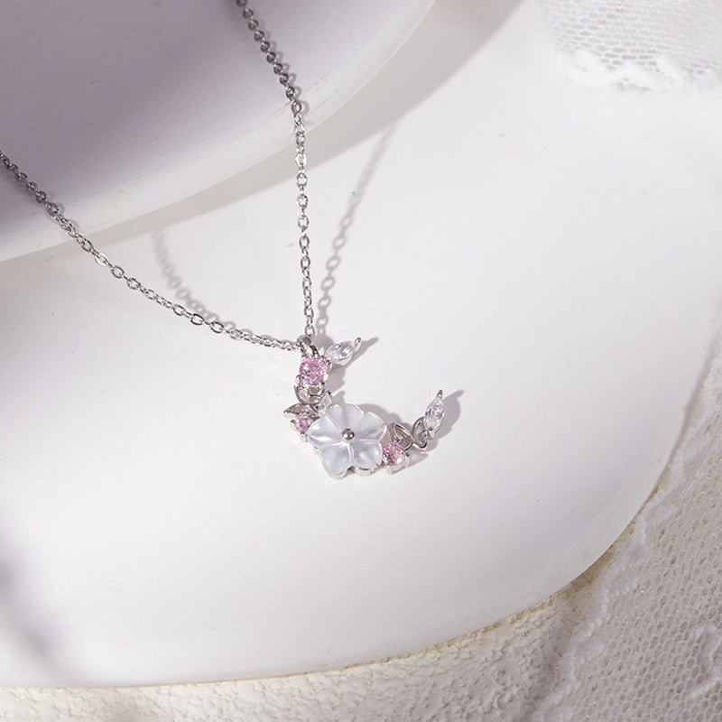 White shell flower and butterfly details on a crescent necklace