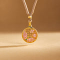 Pink enamel butterfly medallion hanging vertically against a warm golden background
