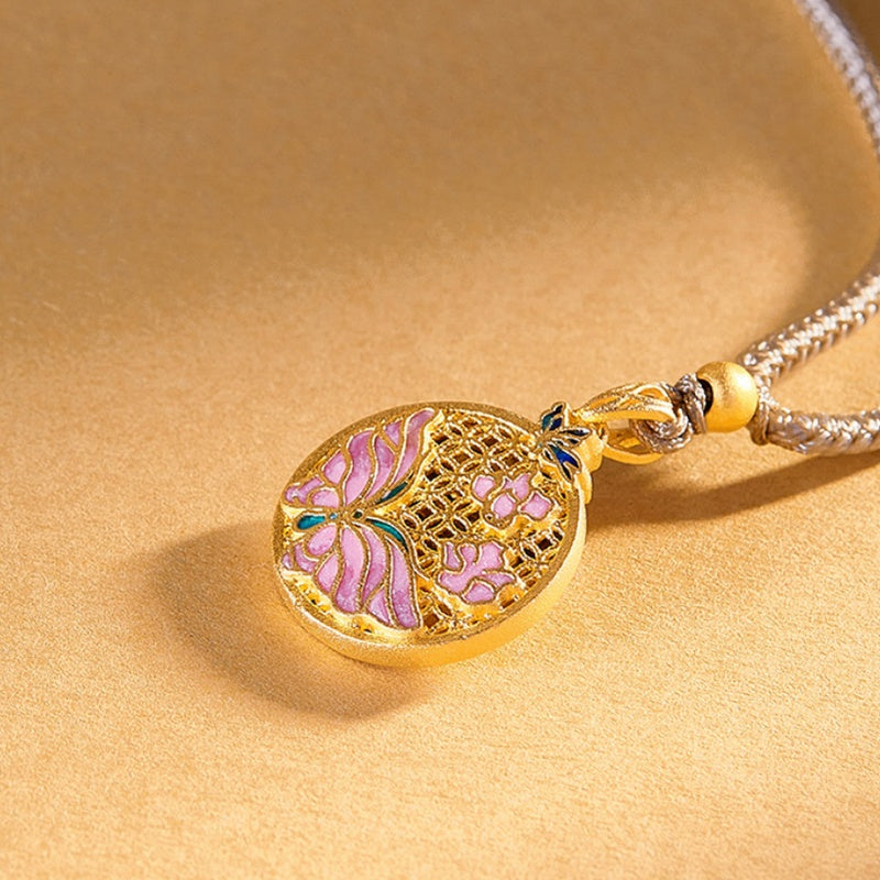 Close view of pink enamel butterflies and openwork filigree on a golden surface