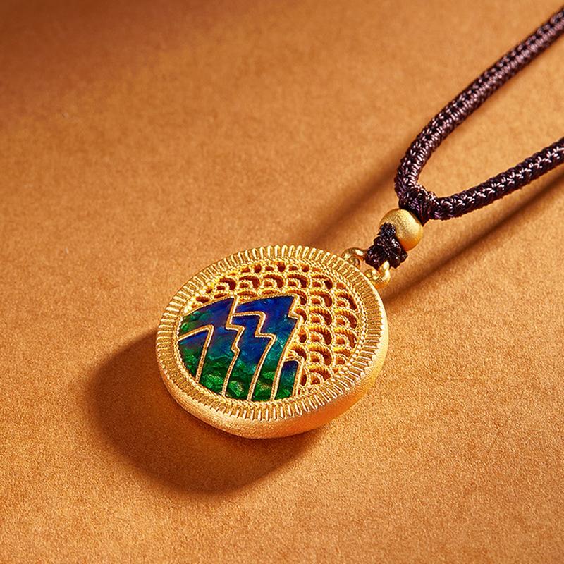 Mountain pendant resting on a warm amber surface