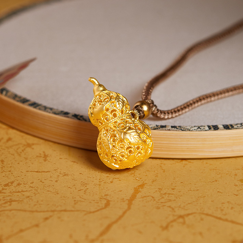 Angled openwork gourd pendant beside a cream tray