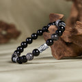 Bamboo black obsidian and black rutilated quartz bracelet on natural wood